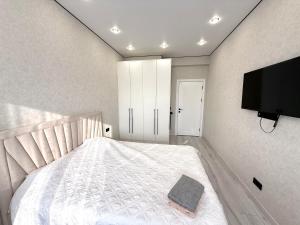 a bedroom with a bed and a flat screen tv at Жилой комплекс Космос in Bishkek +2 photos