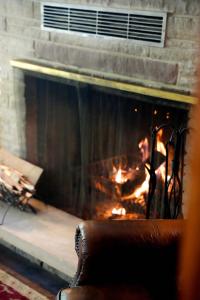 a brick fireplace with a fire in it at Cozy Cabin Retreat in Midway in Mound City