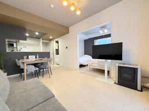 a living room with a television and a dining room at Sun Court Nango-dori サンコート南郷通 1003 in Sapporo