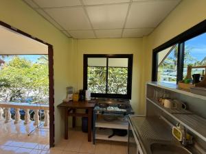 Una cocina con paredes y ventanas amarillas y una mesa. en Chill House, en Ko Pha Ngan