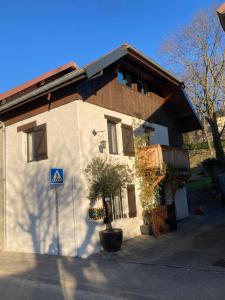 a white building with a tree in front of it at Maison deux chambres avec grand jardin in Grésy-sur-Aix