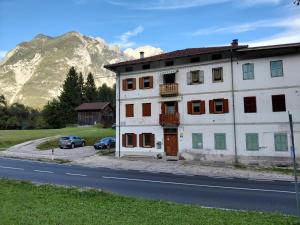 a building on the side of a road with a mountain at Da Mario in Auronzo di Cadore