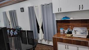 a kitchen with white cabinets and a counter with a table at The happy nook in General Santos