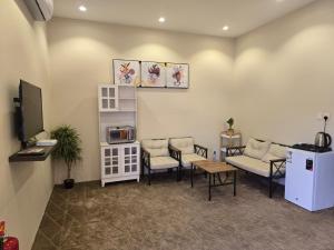 Sala de espera con sofá, sillas y TV en Marasi, en Al Ula 5 fotos más