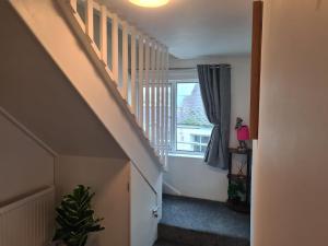 a hallway with a staircase and a window at Cosy Townhouse Within Caernarfon's Old Town Walls in Caernarfon +9 photos