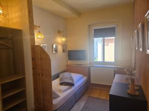 a small room with a bed and a window at Pension Zur Neuenburg in Freyburg