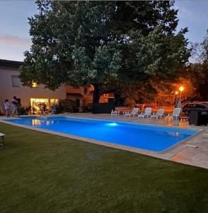 a swimming pool in a yard with chairs and a tree at Le Grand Tilleul in Draguignan