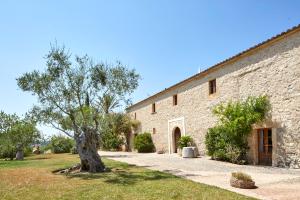 a stone building with a tree in front of it at Son Gener Hotel Spa in Son Servera