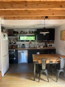 a kitchen with a wooden ceiling and a table and chairs at Maison deux chambres avec grand jardin in Grésy-sur-Aix