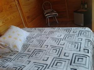 1 cama con almohada y silla en una habitación en Pousada Caverna Rio dos Bugres, en Urubici