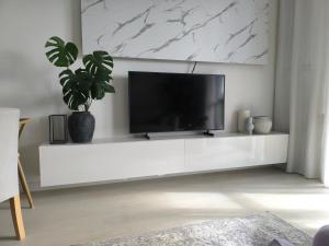 a living room with a tv on a white entertainment center at Apart Platinum in Stargard
