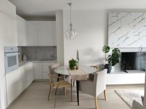 a white kitchen with a table and chairs at Apart Platinum in Stargard