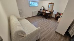 a living room with two white couches and a desk at Chambres meublées, Tv sdb wc et accès privatifs in Champigny-sur-Marne