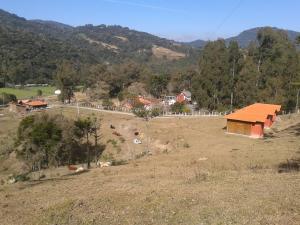 a small house on a hill in a field at Pousada Caverna Rio dos Bugres in Urubici