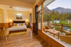 una habitación de hotel con una cama y un balcón en The Winterfell Resort, Kasol, en Kasol