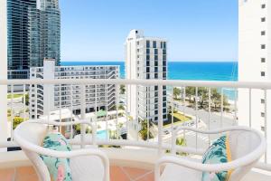 a balcony with two chairs and a view of the ocean at Studio Bliss by the Sea in Gold Coast