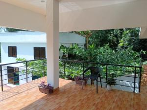 a balcony with a black chair and some plants at Nodir Neer - Nest by the River in Fatepur