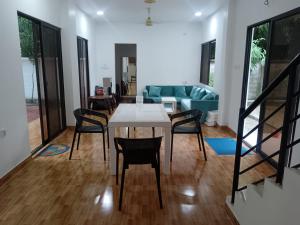 a living room with a table and chairs and a couch at Nodir Neer - Nest by the River in Fatepur