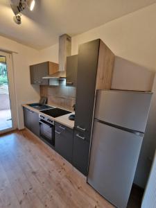 a kitchen with a stainless steel refrigerator and wooden floors at Ferienwohnung Neuss-Süd in Neuss