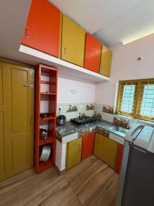 a kitchen with yellow and orange cabinets and a kitchen at Epic inn villa 3 bhk with kitchen Varkala cliff in Varkala