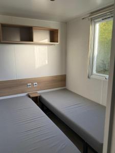 two beds in a room with a window at L'Eleganzia Piscines et nature en Normandie in Litteau +29 photos