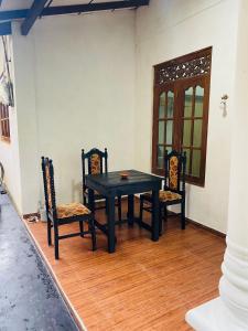 Un comedor con una mesa negra y dos sillas. en Sandy Coconut Guest, en Mirissa 30 fotos más
