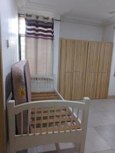 DawhwenyaにあるThe Thomasevic Placeのベビーベッドと木製の戸棚のある部屋