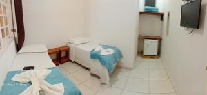 a hospital room with a bed and a tv at Pousada Cama e Café Conservatória in Conservatória