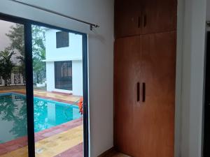 a sliding glass door leading to a swimming pool at Nodir Neer - Nest by the River in Fatepur