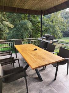 a wooden table and chairs on a patio with a grill at Ferienhaus Heiligenmühle in Leinburg