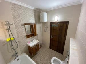 un bagno con lavandino, WC e specchio di MOH Homestay a Aydūn
