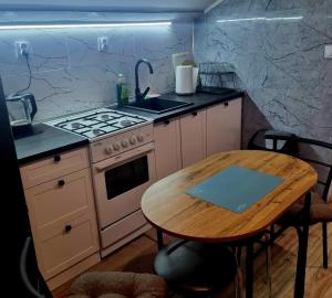 a kitchen with a stove and a wooden table at Dom Kopernica 5 in Chełm