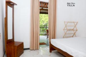 1 dormitorio con cama, espejo y balcón en Aluth Gedara Villa, en Talpe