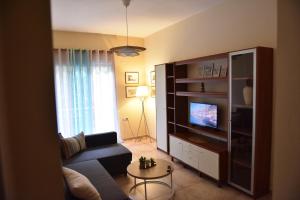a living room with a couch and a tv at Mavi Stay in Alexandroupoli