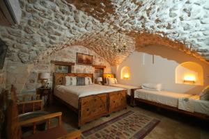 a bedroom with two beds and a stone wall at BABIL ANTIQUE HOTEL in Urfa +134 photos