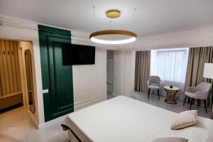 a bedroom with a bed and a flat screen tv at Luxury House in Drăgăşani +8 photos
