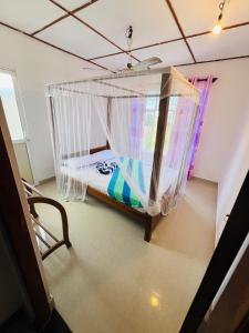 Cama en habitación con red en Sandy Coconut Guest, en Mirissa