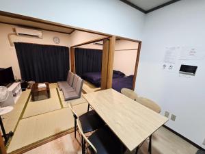 a room with a table and chairs and a bedroom at ZEUS choice FUKUOKA in Fukuoka