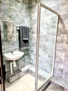 un baño con ducha y lavabo en GlowtiAirbnb, en Centurion
