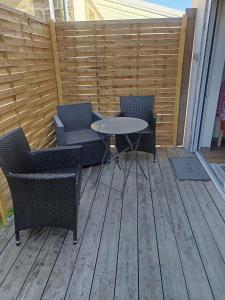 eine Terrasse mit zwei Stühlen und einem Tisch auf einem Deck in der Unterkunft Dépendance meublée avec terrasse in Carbon-Blanc