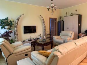 a living room with a couch and chairs and a table at COZY APARTMENT ERNESTA 90m in the city centre - three rooms with balcony in Rīga