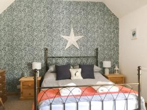 a bedroom with a bed with a star on the wall at The Brae Steading in Fordyce +4 photos
