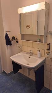 Un baño con un lavabo blanco y un espejo. en Chalet Gold, en Affoltern 8 fotos más