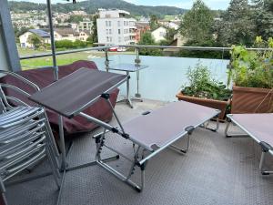 Un patio con mesas y sillas en un balcón. en Chalet Gold, en Affoltern