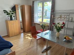 Una sala de estar con una mesa de cristal y sillas. en Chalet Gold, en Affoltern