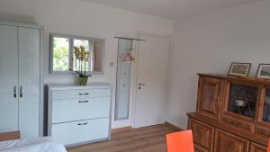 Habitación blanca con vestidor y ventana en Chalet Gold, en Affoltern