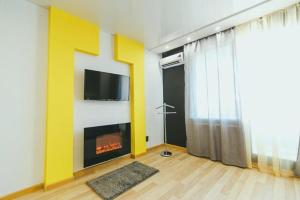 スームィにあるCenter Apartの暖炉とテレビのあるリビングルーム