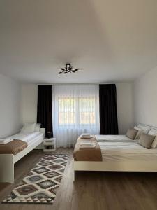 a bedroom with two beds and a window at Colt de Apuseni Guesthouse  +19 photos