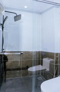 a bathroom with a glass shower with a toilet at Văn Lâm Hotel 