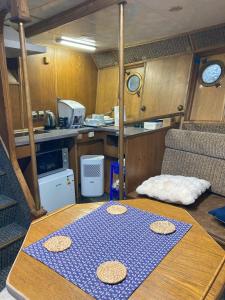 une petite cuisine avec une table au milieu dans l'établissement LOTOSS ex ice class Pilot ship, à Engure